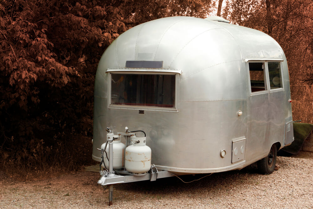 small rv with two propane tanks and regulators