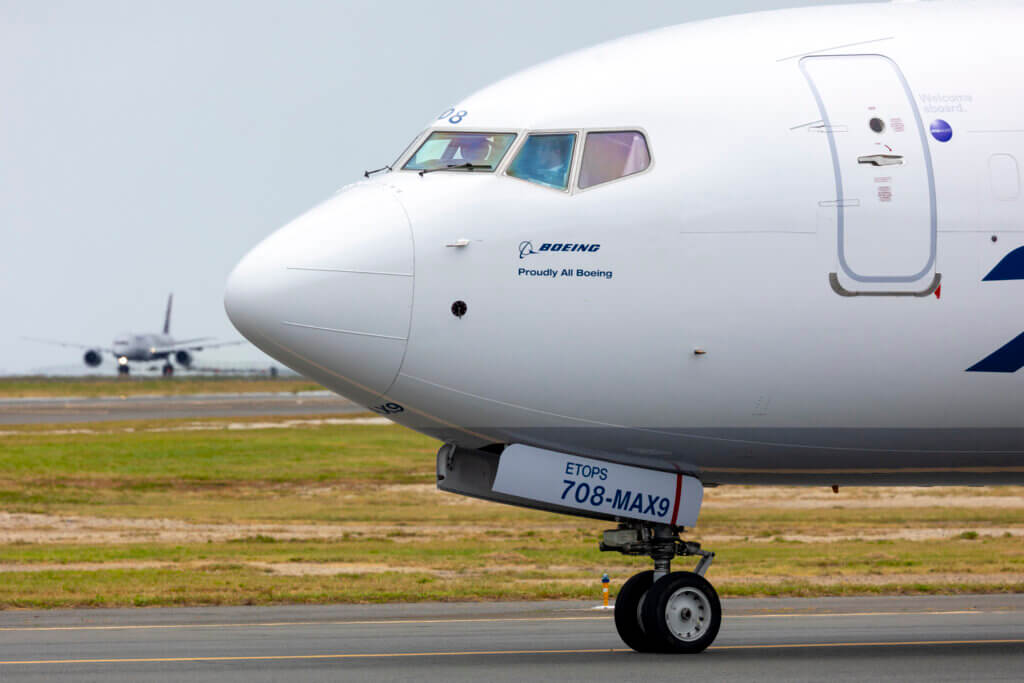 Alaska Air Boeing 737 MAX 9 holds short as a Hawaiian Airlines Boeing 787 begins its takeoff roll